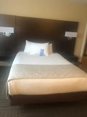 a bedroom with a large bed with white sheets and pillows at Days Inn by Wyndham Hinton in Hinton