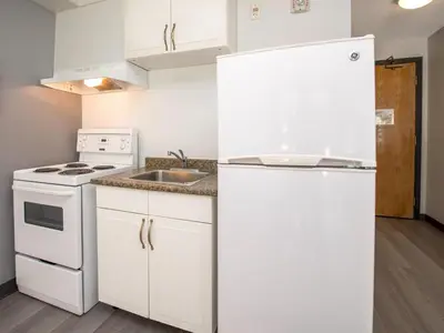 a white kitchen with a sink and a refrigerator at Coast Hinton Hotel in Hinton