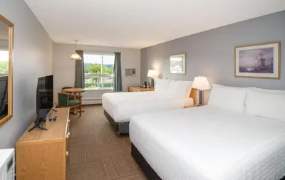 a hotel room with two beds and a flat screen tv at Coast Hinton Hotel in Hinton