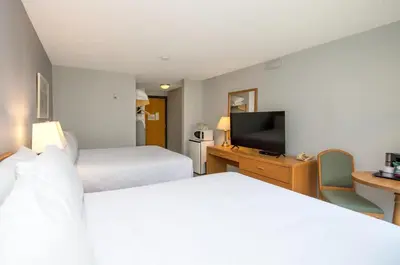 a hotel room with two beds and a flat screen tv at Coast Hinton Hotel in Hinton