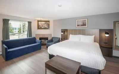 a hotel room with a bed and a blue couch at Coast Hinton Hotel in Hinton