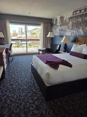 a hotel room with a large bed and a large window at The Royal Anne Hotel in Kelowna