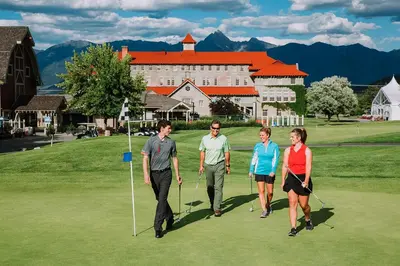a group of people walking on a golf course at St. Eugene Golf Resort & Casino in Cranbrook