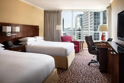 a hotel room with two beds and a desk at Vancouver Marriott Pinnacle Downtown Hotel in Vancouver