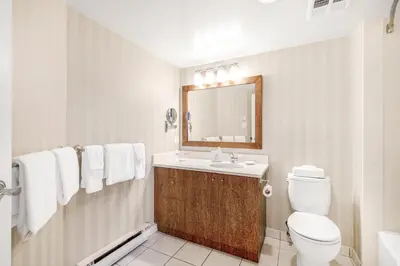 a bathroom with a toilet and a sink and a mirror at Victoria Regent Waterfront Hotel & Suites in Victoria