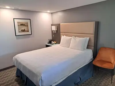 a hotel room with a large bed and a chair at Best Western Plus Vancouver Airport Hotel in Vancouver