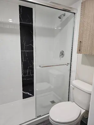 a bathroom with a glass shower with a toilet at Western Budget Motel #1 Leduc/Nisku in Leduc