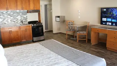 a kitchen with a stove and a table and a counter at Western Budget Motel #1 Leduc/Nisku in Leduc