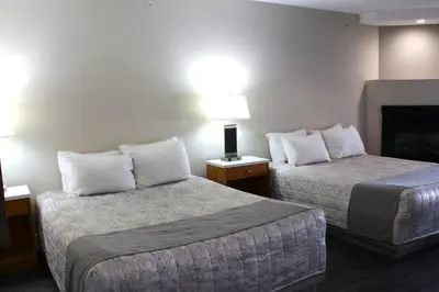 a hotel room with two beds and a fireplace at Western Budget Motel #1 Leduc/Nisku in Leduc