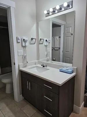 a bathroom with a sink and a large mirror at Western Budget Motel #1 Leduc/Nisku in Leduc