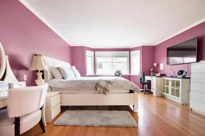a bedroom with purple walls and a bed and a desk at Fraser River Richmond Bed and Breakfast in Richmond