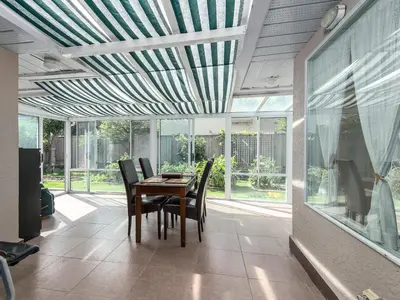 a dining room with a table and chairs and windows at Fraser River Richmond Bed and Breakfast in Richmond