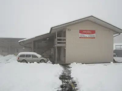 a car parked in front of a building in the snow at Star Lodge in Kamloops