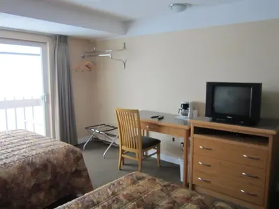 a hotel room with a desk with a television and a bed at Star Lodge in Kamloops