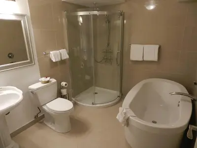 a bathroom with a shower and a toilet and a sink at Arbutus Inn in Victoria