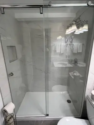 a shower with a glass door in a bathroom at Arbutus Inn in Victoria