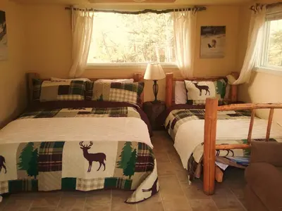 a bedroom with two twin beds and a window at Eagle Bear Lodge in Tatla Lake