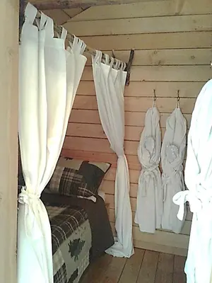 a bedroom with white curtains and a bed at Eagle Bear Lodge in Tatla Lake