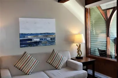 a living room with a couch and a table with a lamp at Beautiful Condo In A Great Location, Oceanfront Complex - Oe in Ucluelet