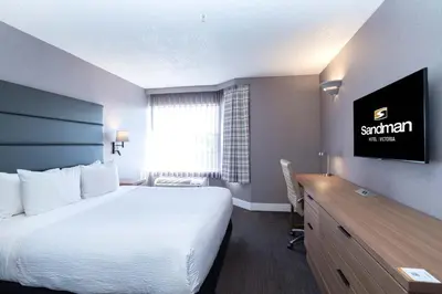 a hotel room with a bed and a desk at Sandman Hotel Victoria in Victoria