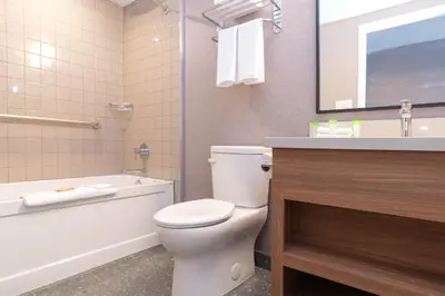 a bathroom with a toilet and a tub and a sink at Sandman Hotel Victoria in Victoria