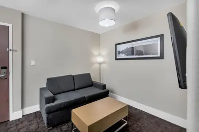 a living room with a chair and a table at Sandman Hotel Grande Prairie in Grande Prairie