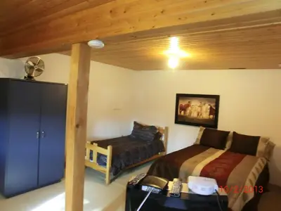 a bedroom with two beds and a table with a suitcase at Invermere 4 Br Lakeside, Mountain View Home! Walk to Sandy Beach for Swimming, Boating, Tennis and Beach Volleyball Local Town Shopping, Eateries, Bakery and Pubs! Welcome Family's, Healthcare Workers and Trades! Monthly Rentals of 28 Nights or More! in Invermere