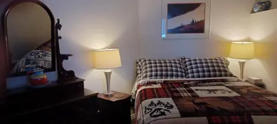 a bedroom with a bed with two lamps and a mirror at Deer Ridge B&B in Golden