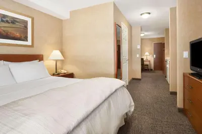 a hotel room with a bed and a flat screen tv at Days Inn & Suites by Wyndham Cochrane in Cochrane