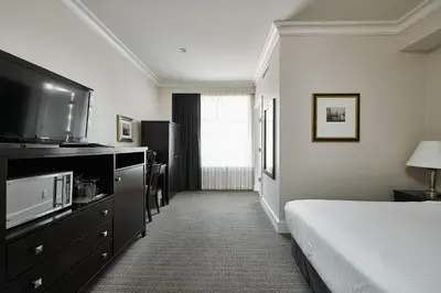 a hotel room with a bed and a flat screen tv at Hotel Rialto in Victoria