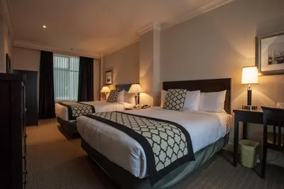 a hotel room with two beds and two lamps at Hotel Rialto in Victoria