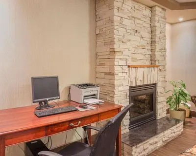 an office with a desk with a computer and a fireplace at Comfort Inn & Suites University in Calgary