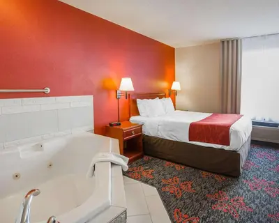 a hotel room with a bed and a bath tub at Comfort Inn & Suites University in Calgary