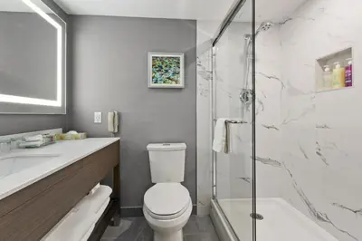 a bathroom with a toilet and a sink and a shower at Best Western Premier Calgary Plaza Hotel & Conference Centre in Calgary
