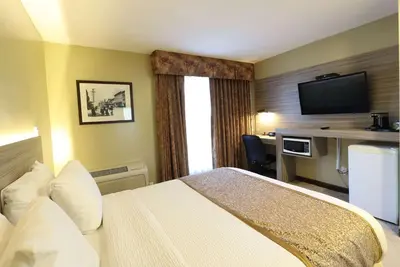 a hotel room with a bed and a flat screen tv at Days Inn by Wyndham Surrey in Surrey