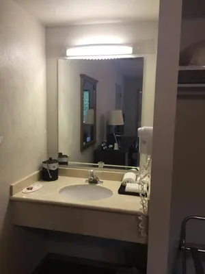 a bathroom with a sink and a large mirror at Super 8 by Wyndham Kelowna BC in Kelowna
