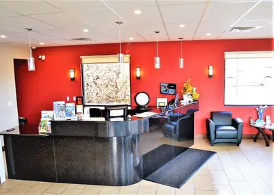 a waiting room with red walls and a counter at Super 8 by Wyndham Kelowna BC in Kelowna