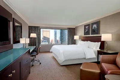 a large hotel room with a bed and a desk at The Westin Calgary in Calgary