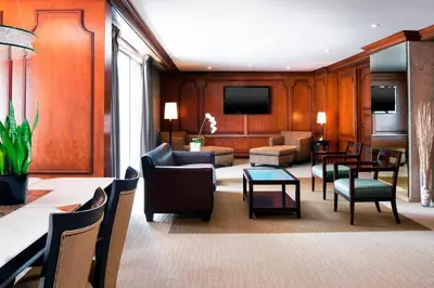 a hotel room with a waiting area with tables and chairs at The Westin Calgary in Calgary
