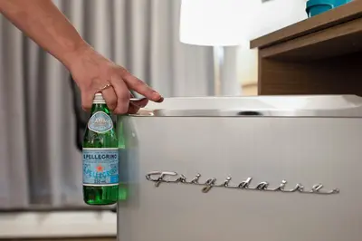 a person holding a bottle of beer in a refrigerator at Highliner Hotel in Prince Rupert