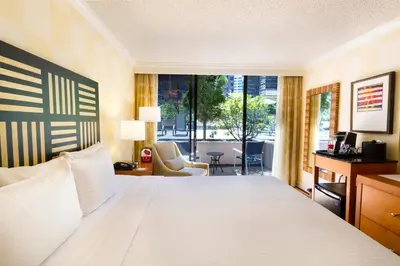 a bedroom with a large white bed and a large window at Pinnacle Hotel Harbourfront in Vancouver