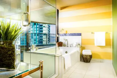 a bathroom with a glass shower and a sink at Pinnacle Hotel Harbourfront in Vancouver