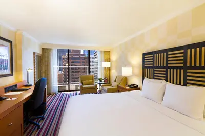 a hotel room with a bed and a desk and a window at Pinnacle Hotel Harbourfront in Vancouver