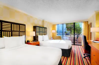 a hotel room with two beds and a balcony at Pinnacle Hotel Harbourfront in Vancouver