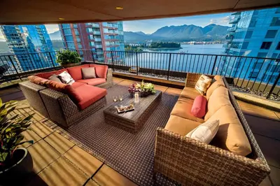 a balcony with a couch and chairs and a table at Pinnacle Hotel Harbourfront in Vancouver