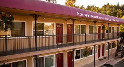 a building with red doors and a balcony at The Classic Horseshoe Bay Motel in Horseshoe Bay
