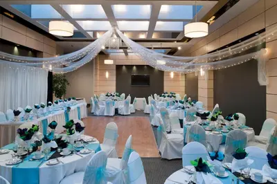 a banquet hall with white tables and chairs at Ramada Plaza by Wyndham Prince George in Prince George