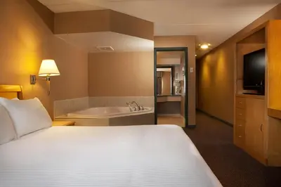 a hotel room with a bed and a bath tub at Ramada Plaza by Wyndham Prince George in Prince George