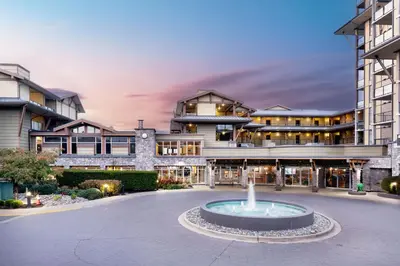a building with a fountain in the middle of a courtyard at The Beach Club Resort — Bellstar Hotels & Resorts in Parksville