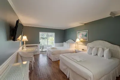 a hotel room with two beds and a flat screen tv at South Thompson Inn & Conference Centre in Kamloops